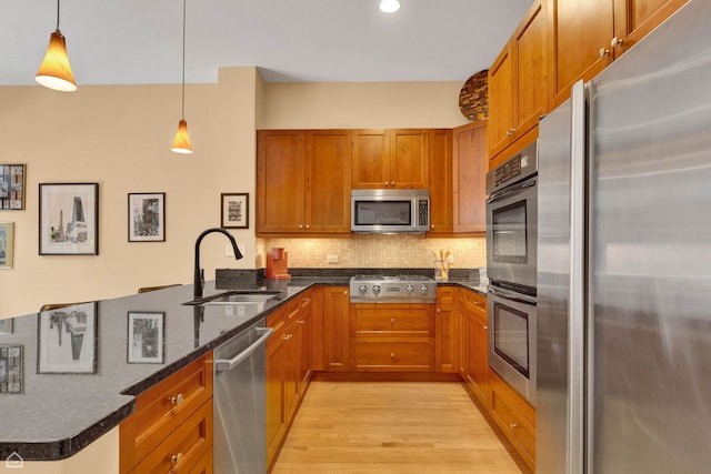 2862 N Paulina St, Chicago, IL 60657 - kitchen featuring appliances with stainless steel finishes, a sink, light wood finished floors, a peninsula, and brown cabinetry