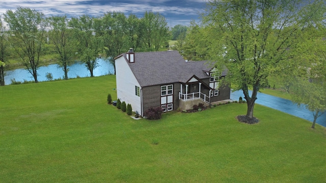 500 Muscovy Ln, Bloomingdale, IL 60108 - view of front of house featuring a water view, concrete driveway, a chimney, a shingled roof, and a front lawn
