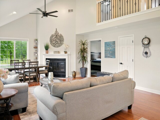 500 Muscovy Ln, Bloomingdale, IL 60108 - living area featuring high vaulted ceiling, a ceiling fan, a glass covered fireplace, wood finished floors, and baseboards
