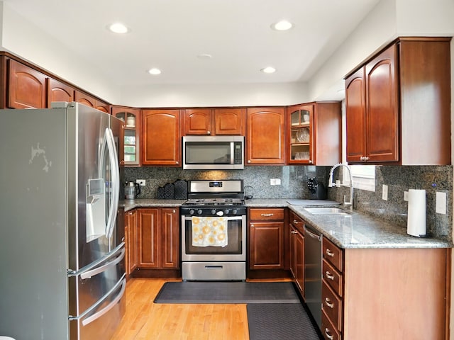 500 Muscovy Ln, Bloomingdale, IL 60108 - kitchen with stainless steel appliances, a sink, light wood-type flooring, light stone counters, and tasteful backsplash
