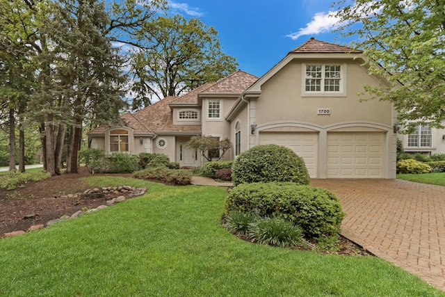 1700 Cornell Ct, Lake Forest, IL 60045 - view of front of property featuring stucco siding, a front lawn, driveway, and an attached garage