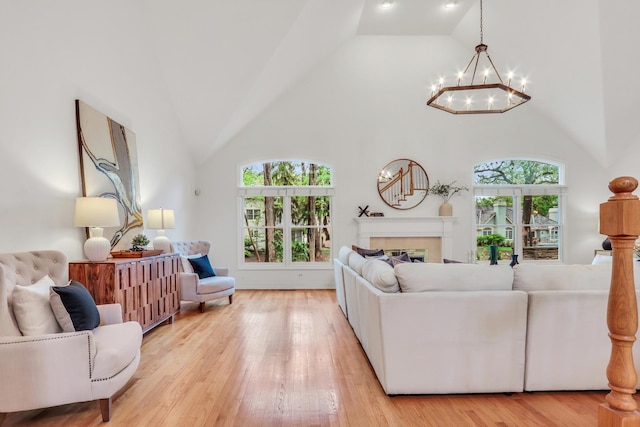 1700 Cornell Ct, Lake Forest, IL 60045 - living area featuring a chandelier, high vaulted ceiling, light wood-type flooring, and a tiled fireplace