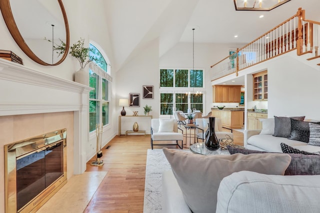 1700 Cornell Ct, Lake Forest, IL 60045 - living room with a towering ceiling, a tiled fireplace, a chandelier, light wood-style flooring, and stairway