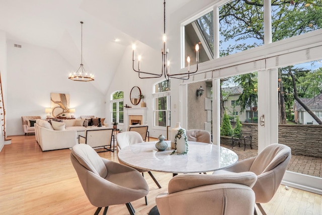 1700 Cornell Ct, Lake Forest, IL 60045 - dining room featuring a chandelier, high vaulted ceiling, light wood finished floors, and a fireplace
