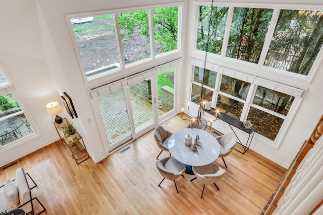 1700 Cornell Ct, Lake Forest, IL 60045 - dining room with wood finished floors, a towering ceiling, a chandelier, and baseboards