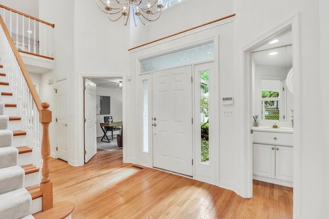 1700 Cornell Ct, Lake Forest, IL 60045 - entryway with light wood-type flooring, stairs, baseboards, a chandelier, and a towering ceiling