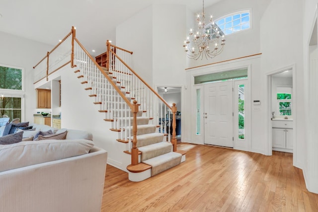 1700 Cornell Ct, Lake Forest, IL 60045 - foyer entrance with a towering ceiling, stairway, light wood-style flooring, a chandelier, and baseboards