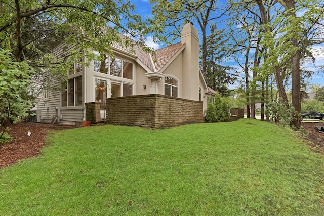 1700 Cornell Ct, Lake Forest, IL 60045 - rear view of house featuring stucco siding, a chimney, a yard, and a sunroom
