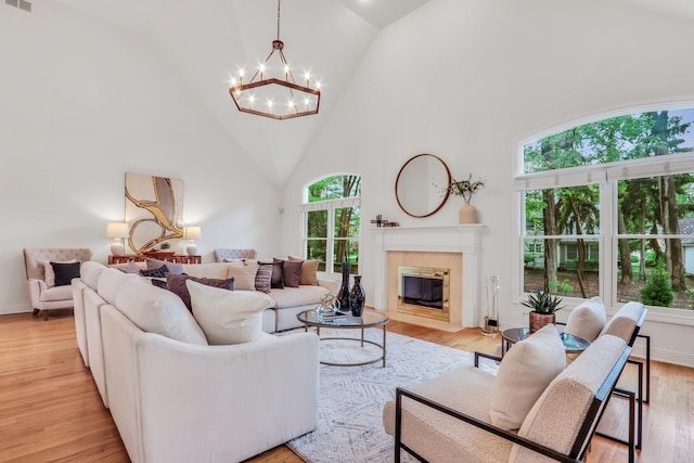 1700 Cornell Ct, Lake Forest, IL 60045 - living room with healthy amount of natural light, a chandelier, high vaulted ceiling, light wood-style flooring, and a fireplace with flush hearth
