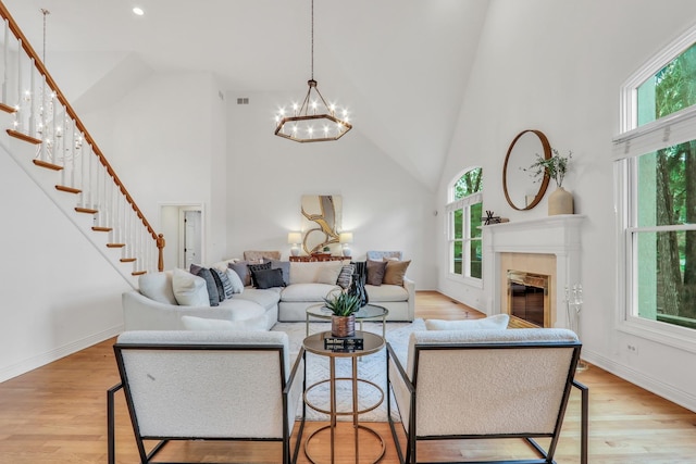 1700 Cornell Ct, Lake Forest, IL 60045 - living area featuring a chandelier, high vaulted ceiling, stairs, light wood-type flooring, and a fireplace