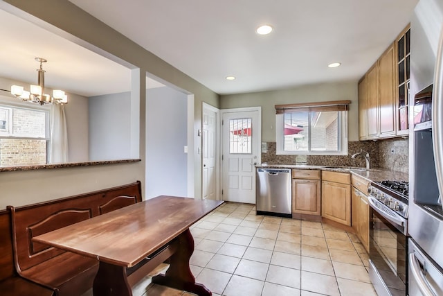 7665 W Victoria St, Chicago, IL 60631 - kitchen with appliances with stainless steel finishes, tasteful backsplash, a chandelier, a sink, and light tile patterned floors