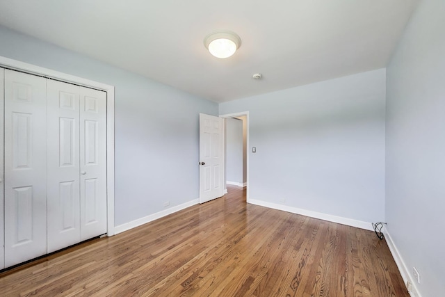 7665 W Victoria St, Chicago, IL 60631 - unfurnished bedroom with baseboards, wood finished floors, and a closet