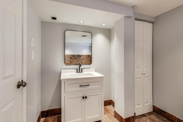 7665 W Victoria St, Chicago, IL 60631 - bathroom with a closet, baseboards, vanity, and decorative backsplash