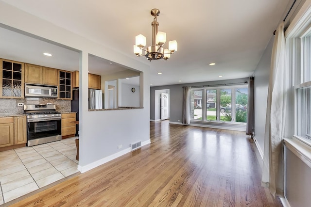 7665 W Victoria St, Chicago, IL 60631 - unfurnished living room with a chandelier, light wood-style flooring, baseboards, and recessed lighting