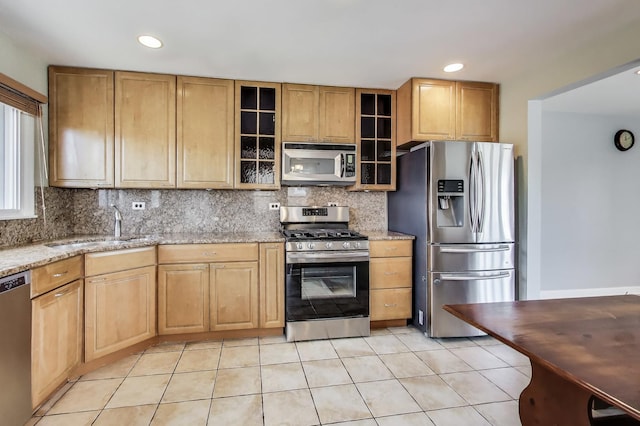 7665 W Victoria St, Chicago, IL 60631 - kitchen featuring stainless steel appliances, a sink, backsplash, light tile patterned floors, and light stone counters