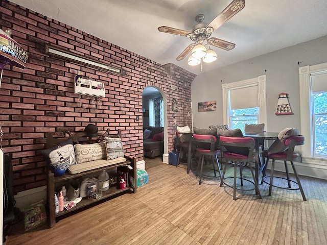 252 Jefferson Ave, Elgin, IL 60120 - dining area with wood-type flooring, ceiling fan, arched walkways, brick wall, and vaulted ceiling