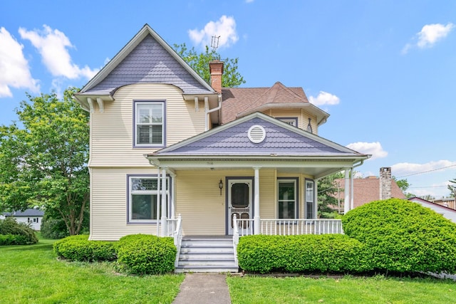 508 Grant St, Earlville, IL 60518 - victorian home with covered porch, a chimney, and a front lawn