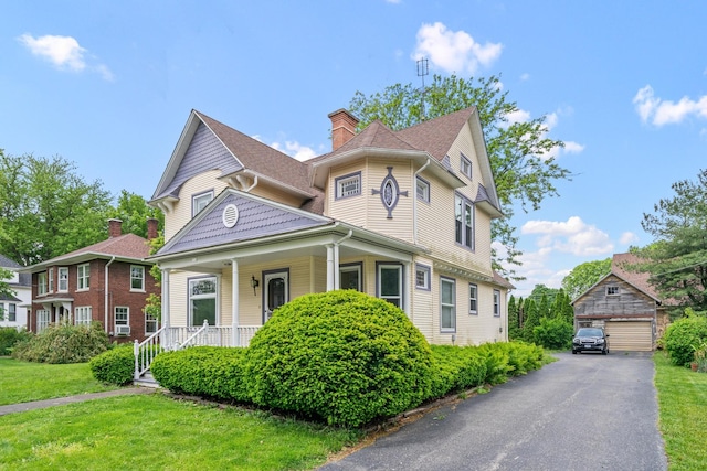 508 Grant St, Earlville, IL 60518 - victorian house with a garage, an outbuilding, a porch, a front lawn, and a chimney