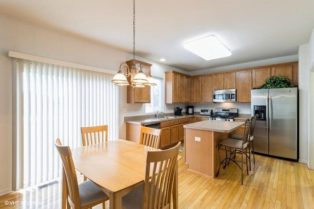 6 Marigold Ln, Algonquin, IL 60102 - kitchen with stainless steel appliances, a sink, a center island, light countertops, and light wood-style flooring