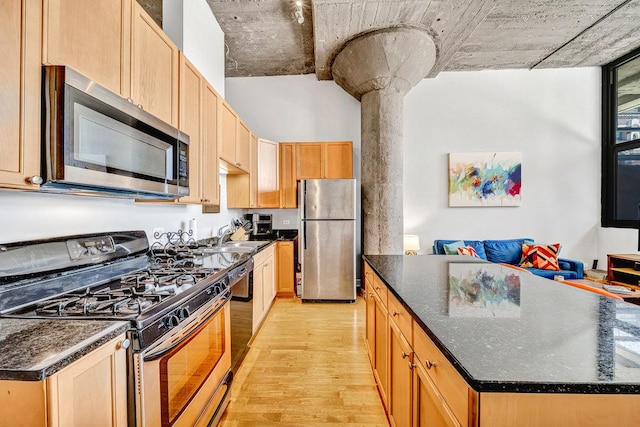 320 E 21st St Unit 412, Chicago, IL 60616 - kitchen featuring appliances with stainless steel finishes, light wood-style flooring, a sink, a kitchen island, and open floor plan
