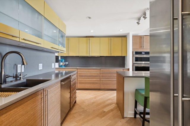 2314 N Lincoln Park W Unit 11S, Chicago, IL 60614 - kitchen with stainless steel appliances, light wood-type flooring, a sink, decorative backsplash, and modern cabinets