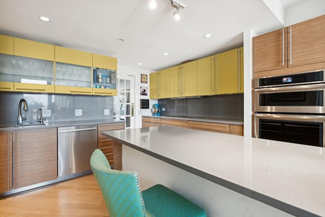 2314 N Lincoln Park W Unit 11S, Chicago, IL 60614 - kitchen featuring stainless steel appliances, a sink, light wood-style flooring, backsplash, and recessed lighting