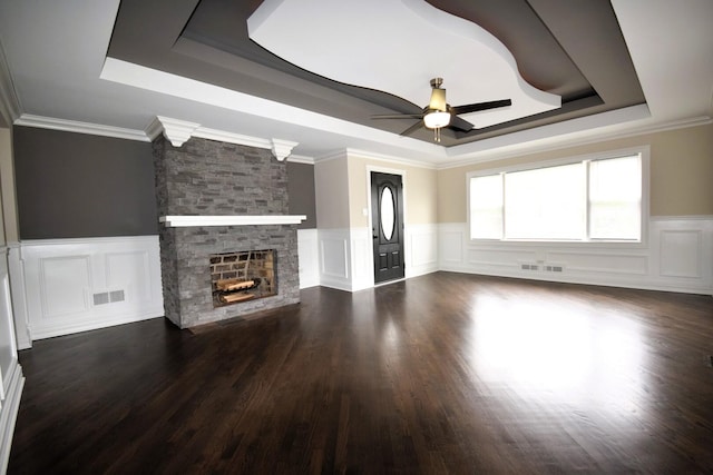 5009 W 79th Pl, Burbank, IL 60459 - unfurnished living room featuring a raised ceiling, ceiling fan, a decorative wall, a wainscoted wall, and a stone fireplace