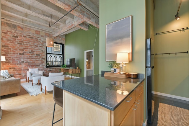 20 N State St Unit 805, Chicago, IL 60602 - kitchen featuring brick wall, wood finished floors, a breakfast bar, a high ceiling, and baseboards
