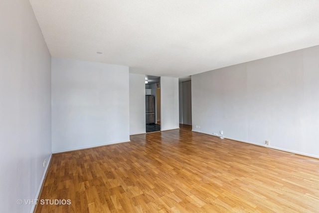 6700 S S Shore Dr Unit 5E, Chicago, IL 60649 - spare room featuring light wood-type flooring and baseboards