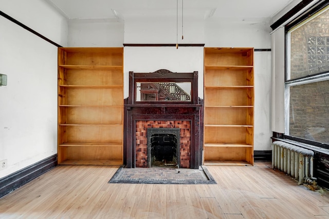 4728 S Evans Ave, Chicago, IL 60615 - unfurnished living room featuring wood finished floors, radiator, a fireplace with flush hearth, and baseboards