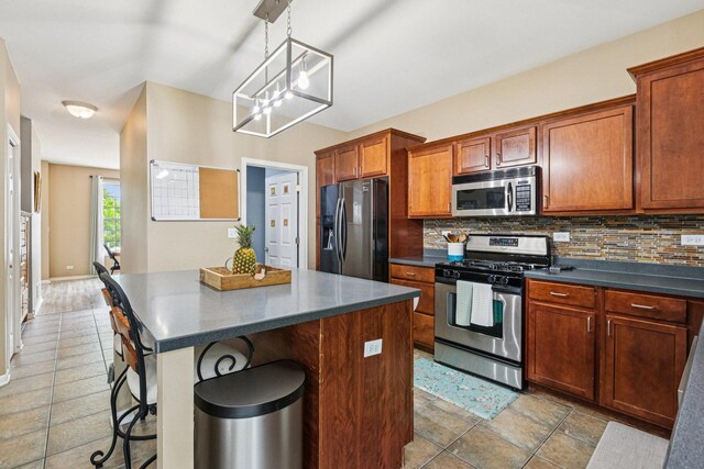 1885 W Greenleaf Ct, Round Lake, IL 60073 - kitchen featuring appliances with stainless steel finishes, dark countertops, decorative backsplash, and a breakfast bar area