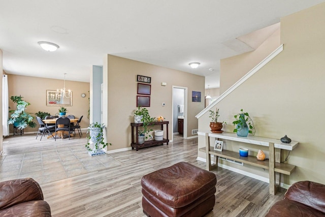 1885 W Greenleaf Ct, Round Lake, IL 60073 - living room with a chandelier, stairs, light wood-style flooring, and baseboards