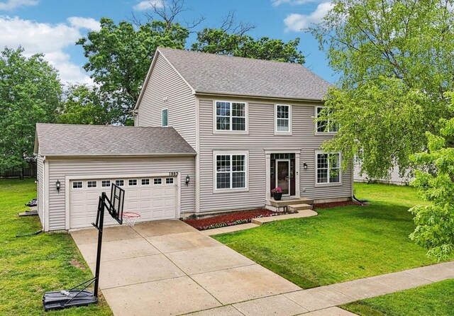 1885 W Greenleaf Ct, Round Lake, IL 60073 - colonial-style house featuring an attached garage, concrete driveway, a front yard, and a shingled roof