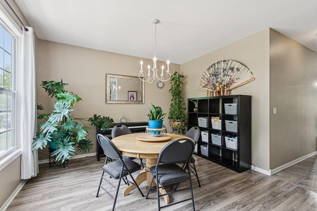 1885 W Greenleaf Ct, Round Lake, IL 60073 - dining room with wood finished floors, a chandelier, baseboards, and healthy amount of natural light