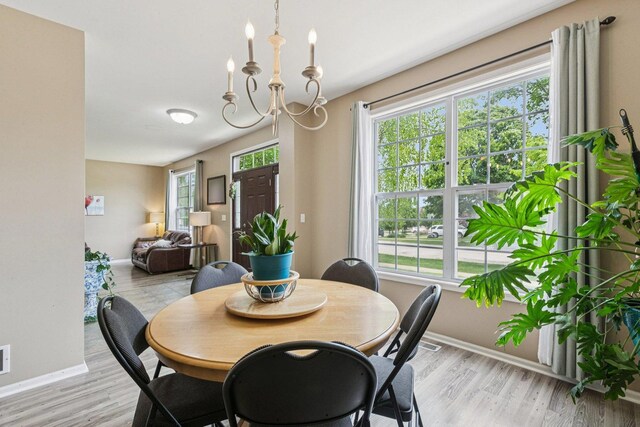 1885 W Greenleaf Ct, Round Lake, IL 60073 - dining area with baseboards, light wood finished floors, and a chandelier