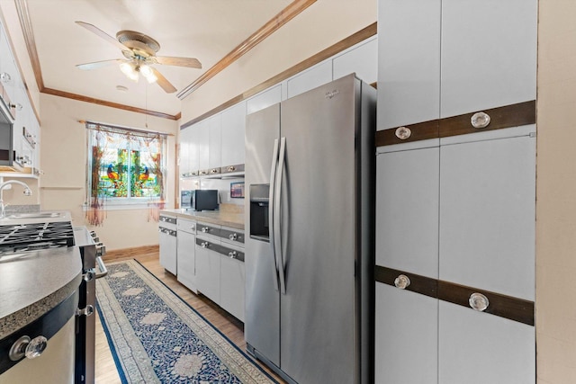 3530 N Lake Shore Dr Unit 12B, Chicago, IL 60657 - kitchen featuring appliances with stainless steel finishes, ceiling fan, ornamental molding, white cabinets, and a sink