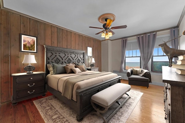 3530 N Lake Shore Dr Unit 12B, Chicago, IL 60657 - bedroom featuring radiator heating unit, wood walls, light wood-type flooring, and ceiling fan