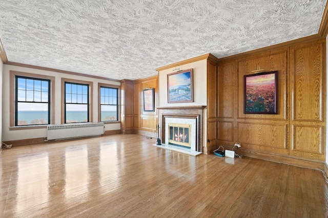 3530 N Lake Shore Dr Unit 12B, Chicago, IL 60657 - unfurnished living room with radiator heating unit, crown molding, a high end fireplace, wood finished floors, and baseboards