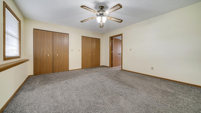 305 S Prairie Ave, Polo, IL 61064 - unfurnished bedroom featuring multiple closets, carpet flooring, baseboards, and a ceiling fan