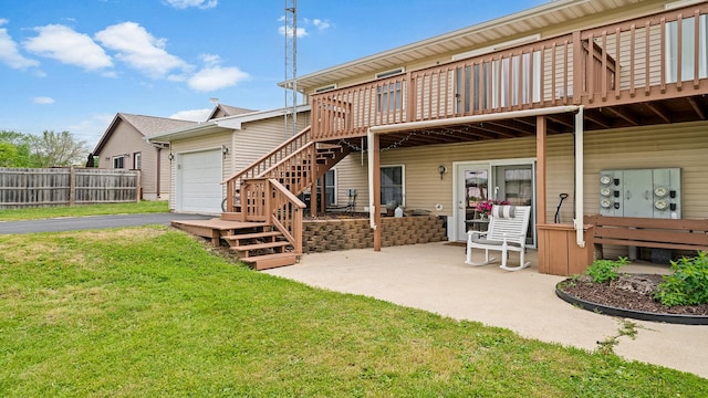 305 S Prairie Ave, Polo, IL 61064 - back of property with a wooden deck, an attached garage, asphalt driveway, and stairs