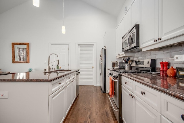 930 W Cuyler Ave Unit 3W, Chicago, IL 60613 - kitchen featuring appliances with stainless steel finishes, white cabinetry, decorative backsplash, dark wood-type flooring, and high vaulted ceiling