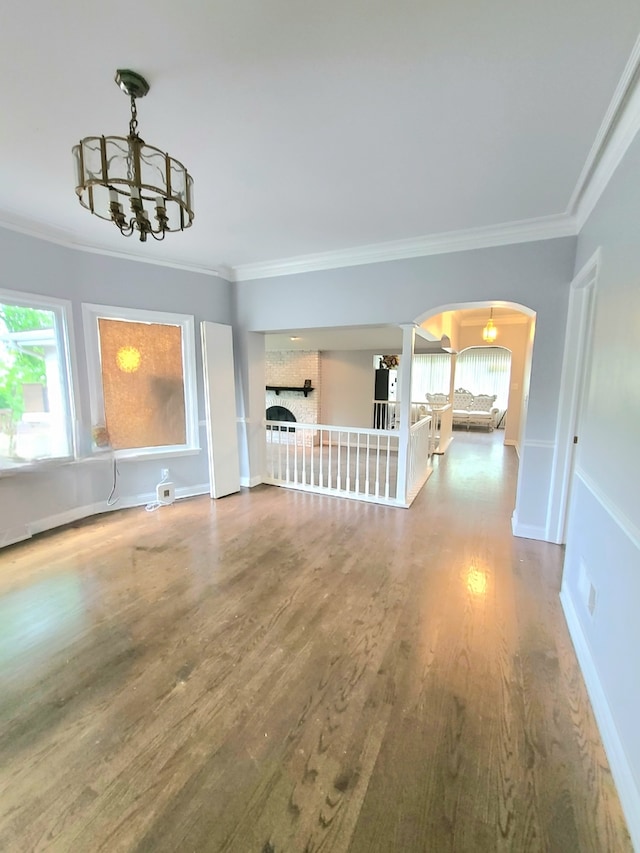 15285 State St, South Holland, IL 60473 - unfurnished living room with a chandelier, arched walkways, wood finished floors, ornamental molding, and baseboards