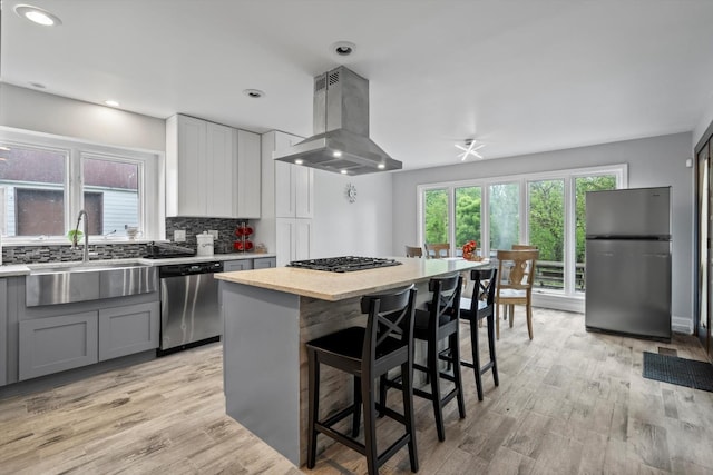 15285 State St, South Holland, IL 60473 - kitchen featuring stainless steel appliances, a sink, island range hood, gray cabinetry, and light wood finished floors