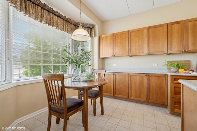 541 N Hough St Unit 205, Barrington, IL 60010 - kitchen with light tile patterned floors, light countertops, brown cabinetry, and decorative light fixtures
