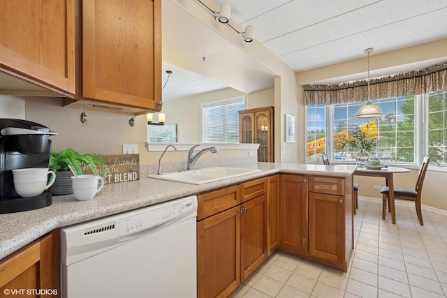 541 N Hough St Unit 205, Barrington, IL 60010 - kitchen with white dishwasher, light countertops, light tile patterned floors, brown cabinetry, and hanging light fixtures
