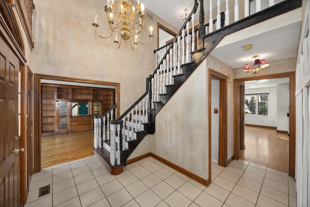 14301 Wooded Path Ln, Orland Park, IL 60462 - foyer entrance featuring a chandelier, light tile patterned floors, stairs, baseboards, and a towering ceiling