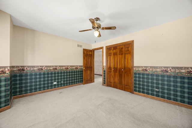 14301 Wooded Path Ln, Orland Park, IL 60462 - unfurnished bedroom with carpet flooring, wainscoting, a closet, ceiling fan, and wallpapered walls