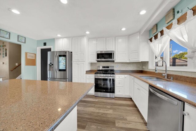 5640 W 82nd Pl, Burbank, IL 60459 - kitchen with stainless steel appliances, a sink, white cabinets, light wood-type flooring, and recessed lighting