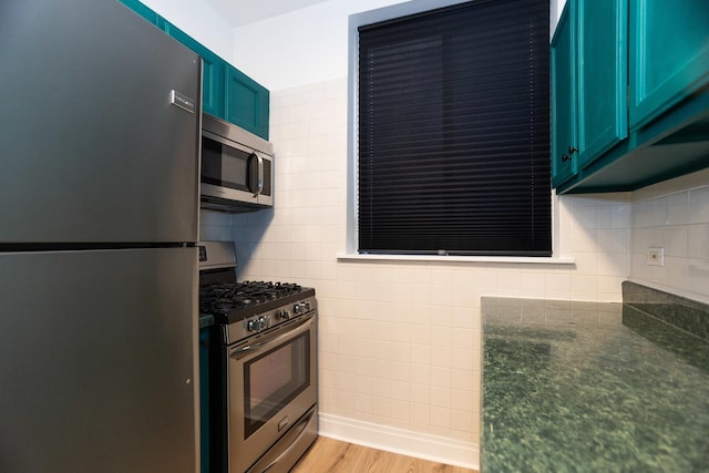 932 W Sunnyside Ave Unit 1C, Chicago, IL 60640 - kitchen with stainless steel appliances, light wood-type flooring, dark stone countertops, and blue cabinetry
