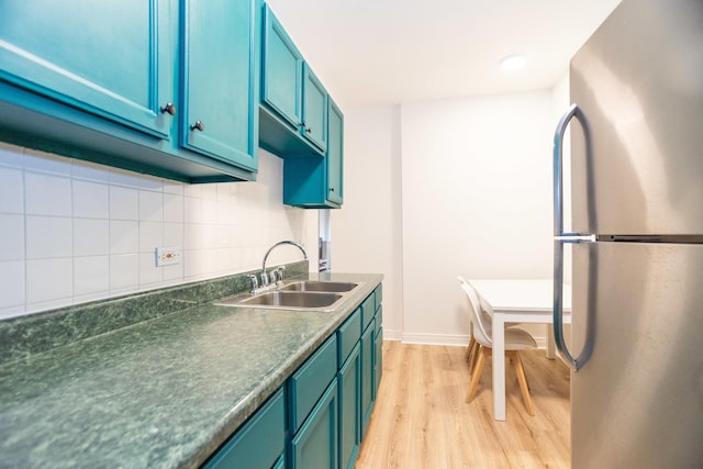 932 W Sunnyside Ave Unit 1C, Chicago, IL 60640 - kitchen featuring freestanding refrigerator, a sink, light wood-style floors, decorative backsplash, and dark countertops